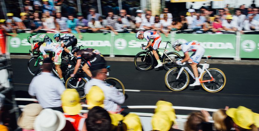 group of people watching cyclist racing
